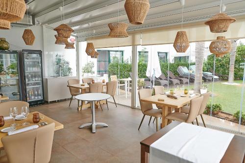 厄尔·波普瑙·德尔·戴尔三角洲拉尔加迪尔酒店的餐厅设有桌椅和窗户。