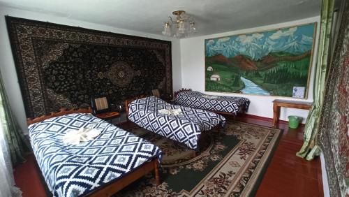 Imeni Karla MarksaGuest House Jekshen的客厅配有两张床,墙上挂有绘画作品