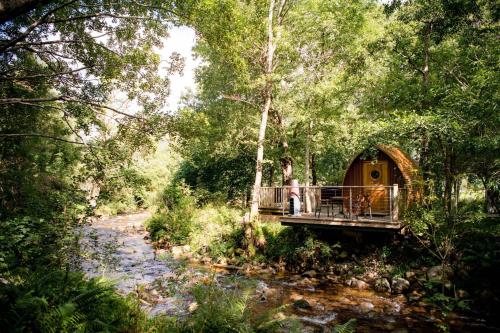 格伦科RiverBeds - Luxury Wee Lodges with Hot Tubs的坐在树屋桥上的女人