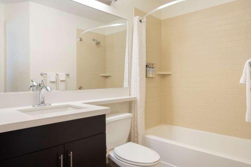 威奇托Sonesta Simply Suites Wichita Airport的浴室配有盥洗盆、卫生间和浴缸。