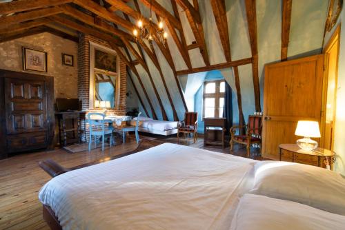 阿姆博斯Manoir de la Maison Blanche的一间带一张大床的卧室,位于一个拥有木制天花板的房间
