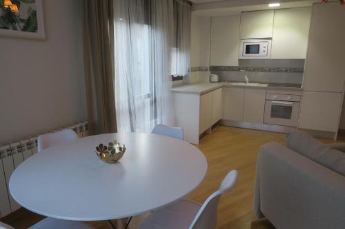 仕格莱Apartamento Calle San Isidro 1ºA的客厅配有白色的桌椅