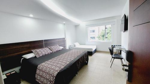 麦德林梅迪特拉内奥酒店的卧室配有床、椅子和窗户。