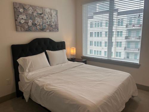休斯顿Resort-Style Apartments near The Galleria的一间卧室设有一张大床和大窗户
