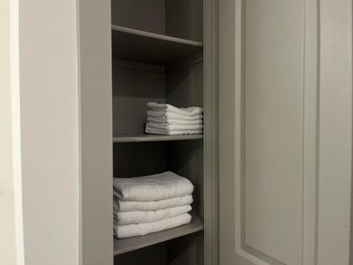 休斯顿Resort-Style Apartments near The Galleria的架子上带白色毛巾的衣柜