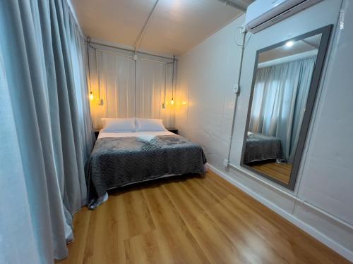Ametista do SulPousada Container e Spa Mina Beer的一间小卧室,配有一张床和镜子