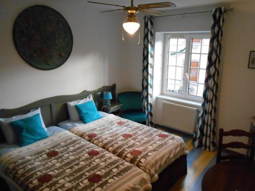 奥尔斯克维莱封地庄园旅馆的一间卧室配有一张带蓝色枕头的床和一扇窗户。