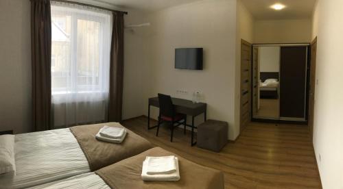 利沃夫Leo Rooms的一间卧室配有一张床、一张桌子和一面镜子