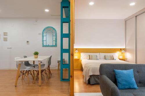 塞维利亚Locksmith Apartment -Wifi- Park Option的一间卧室配有一张床、一张桌子和一张沙发