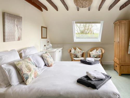 Fitzhead红雀度假屋的卧室配有带毛巾的大型白色床