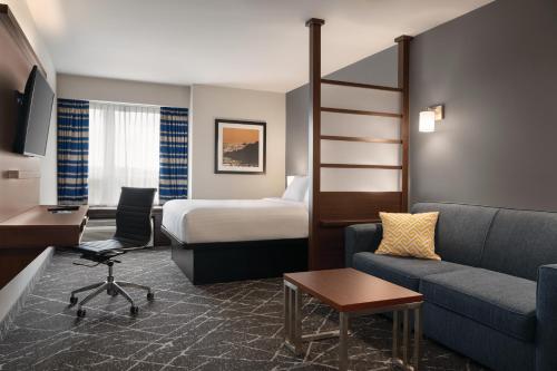 安蒂戈尼什Microtel Inn & Suites by Wyndham Antigonish的酒店客房,配有床和沙发