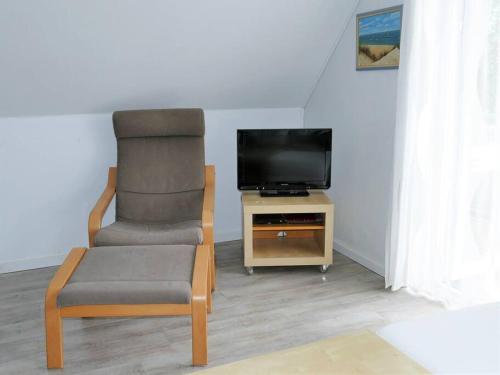 朗格奥Ferienwohnung: Utkiek的客厅配有椅子和电视