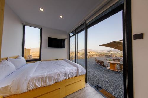 SharīyahGo Camp Mountain Nature Lodge مخيم الطبيعة الجبلية的一间卧室设有一张床和一个大窗户