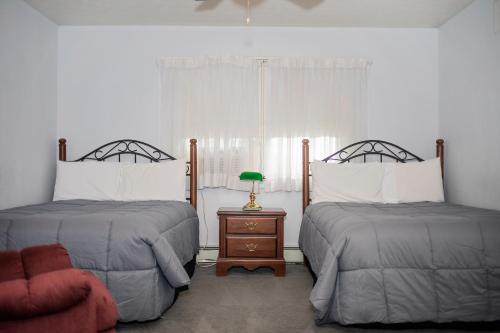 沃特金斯格伦长屋庄园住宿加早餐旅馆的一间卧室配有两张床和一张带台灯的桌子