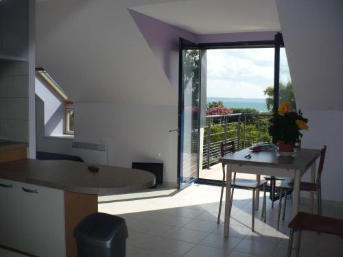 庞特雷Résidence Au Soleil Breton Pentrez的一个带桌子的厨房和一个享有阳台景色的厨房
