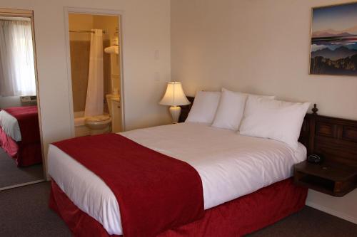 梅德福索瓦纳酒店的酒店客房设有一张带红色毯子的大床