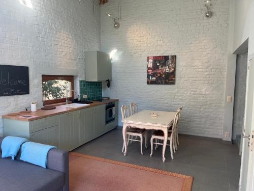 KraainemCosy little house的厨房以及带桌椅的用餐室。