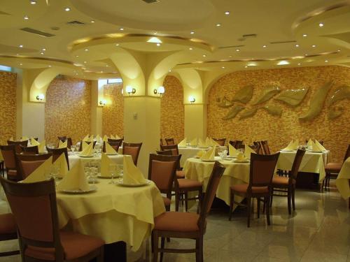 康斯坦察克拉斯酒店的餐厅配有桌椅和白色桌布