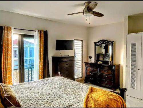 迪斯卡弗里贝Wynters'Escape-gated 1 or 2 Bedroom w PuertoSecoBeach access的一间卧室配有一张床、镜子和电视