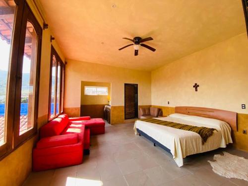 马利纳尔科La Casa del Lago的一间卧室配有一张床、一张沙发和吊扇。
