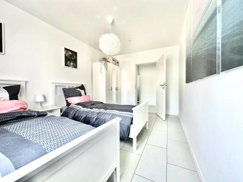 波恩Stilvolles Apartment in Bonn的白色墙壁客房的两张床