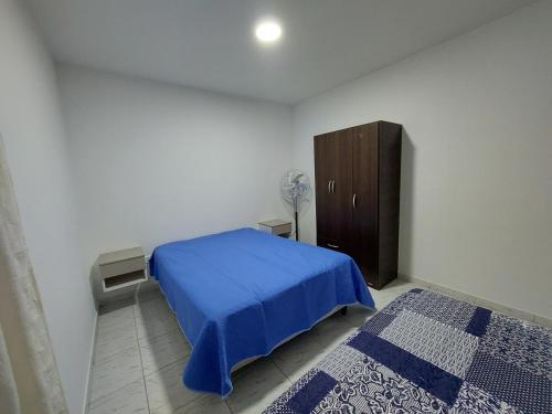 圣罗莎El descanso的一间卧室配有蓝色的床和木制橱柜