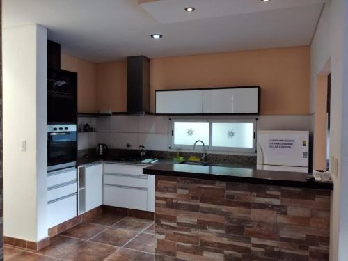 胡宁Casa Quinta Barrio Real的厨房配有白色橱柜和黑色台面