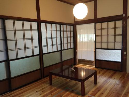 AyabeSatoyama Guest House Couture - Vacation STAY 43859v的客房设有桌子和窗户。
