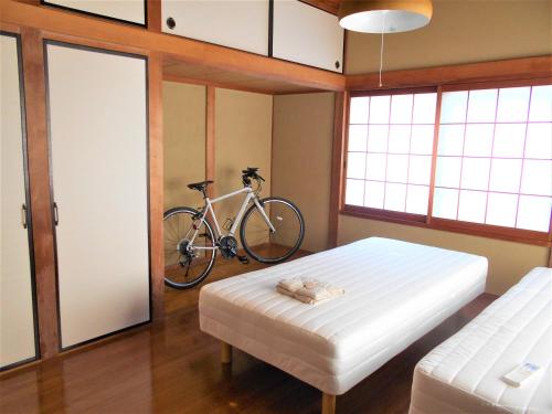 ゲストハウスみちしお的卧室配有一张床,墙上有自行车