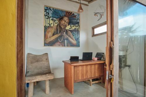 卡拉伊瓦Tamikuã Mar Pousada的办公室,桌子和墙上的绘画