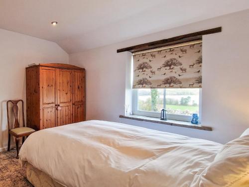 BlagdonThe Barn的一间卧室配有床和带窗帘的窗户