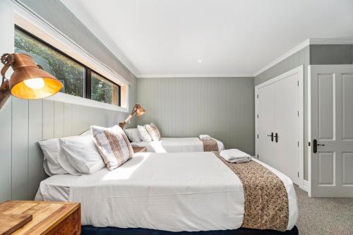 陶波Stagford Retreat Apartment - Taupo的一间卧室设有两张床和窗户。