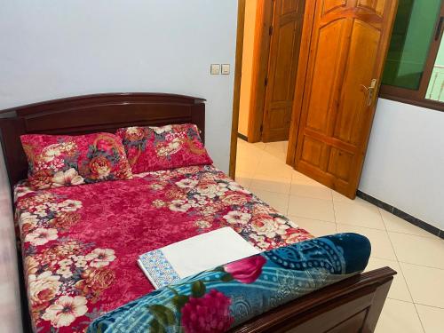 贝尼迈拉勒Appartement Ain Asserdoun的一间卧室配有一张床,上面有一本书