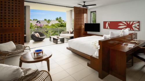 辛加东卡洲际斐济高尔夫度假村及Spa酒店的一间卧室配有一张床,客厅设有阳台