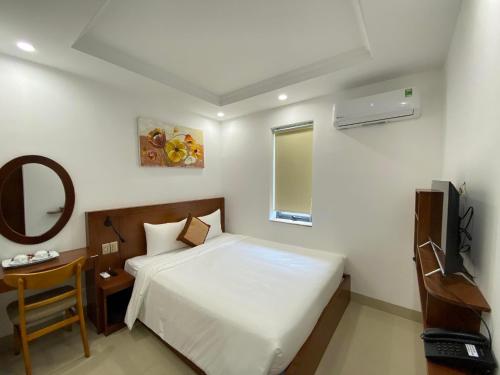 岘港K Hotel Sauna and Massage的一间卧室配有一张床、镜子和电视