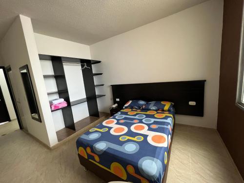 OcañaHotel Marialu的一间卧室配有一张带五颜六色棉被的床
