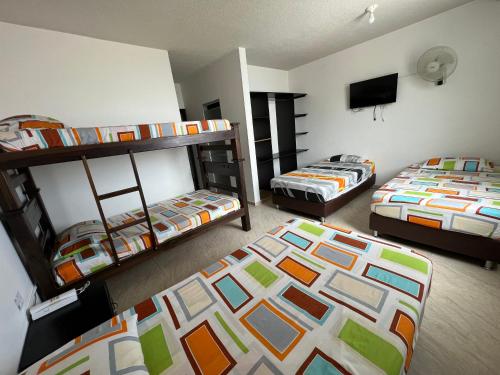 OcañaHotel Marialu的客房设有两张双层床和一台平面电视。