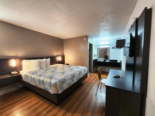 北小石城Motel 6 North Little Rock, AR-JFK Blvd的配有一张床和一张书桌的酒店客房