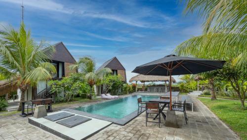 坎古BB Garden Resort的别墅 - 带游泳池和带遮阳伞的桌子