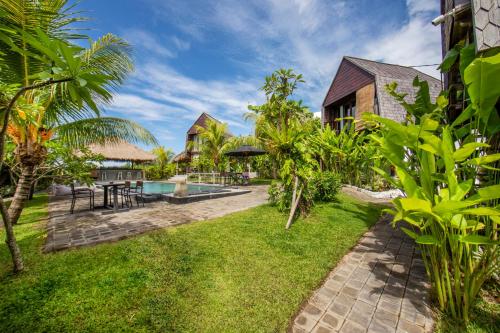 坎古BB Garden Resort的一个带游泳池和草地的度假庭院