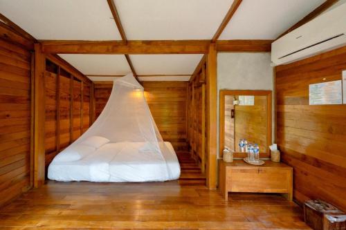 库德岛丛林沽岛度假村 的木墙客房的一张床位
