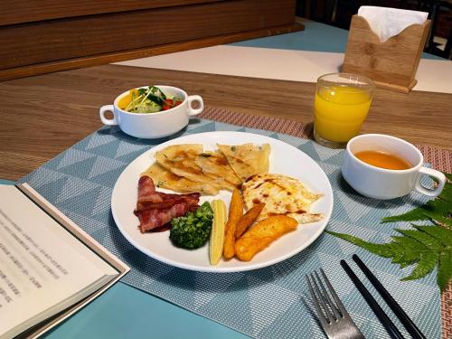 台北洛碁大饭店花华分馆的盘子,有肉,土豆,还有一杯橙汁