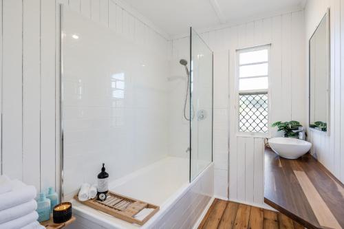 土乌巴Cheerful, Cosy Cottage - Near Rose Garden!的白色的浴室设有浴缸和水槽。