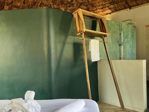 姆托瓦姆布The Jungle Pearl Resort的一间设有绿色墙壁和木梯的房间
