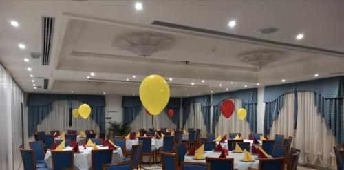 圣艾智德阿拉维HOTEL CONCORDE的宴会厅设有桌子和天花板上的黄色气球