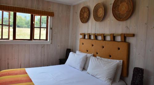 MaanhaarrandIntaba Thulile的一间卧室配有带白色床单和枕头的床。