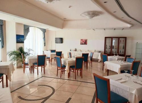 圣艾智德阿拉维HOTEL CONCORDE的一间设有白色桌椅的用餐室