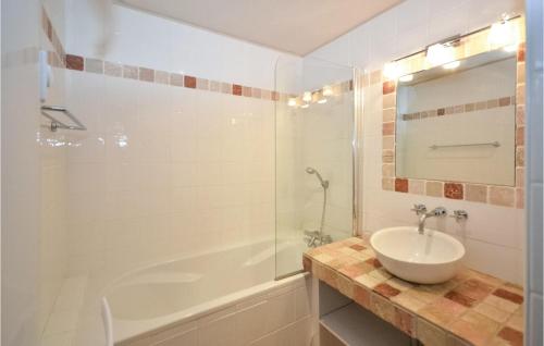 Montblanc圣托马斯高尔夫度假屋的一间带水槽、浴缸和镜子的浴室