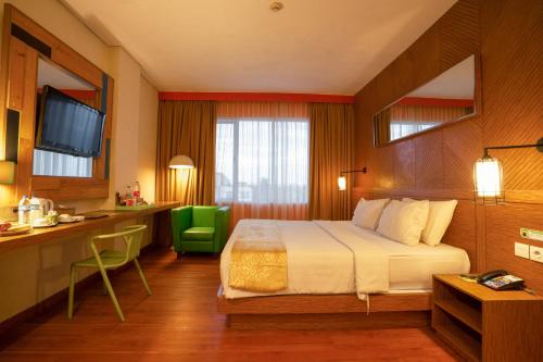 巨港马科斯万帕尔姆邦酒店的配有一张床和一张书桌的酒店客房