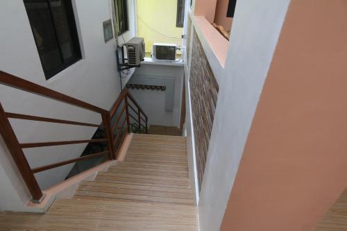 卡利博JM's BnB Hauz Air-conditioned private room的一座铺有木地板的房屋内的楼梯